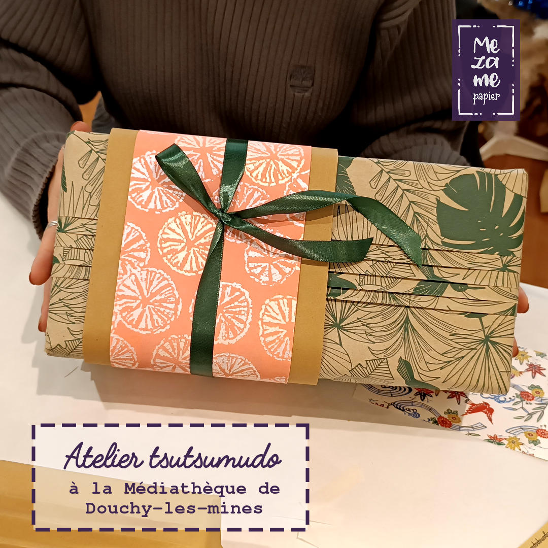 Cadeau emballé dans du papier d'herbe au motif de mostera vert sapin avec un accent de papier japonais rose décoré de tranches d'agrumes irisées