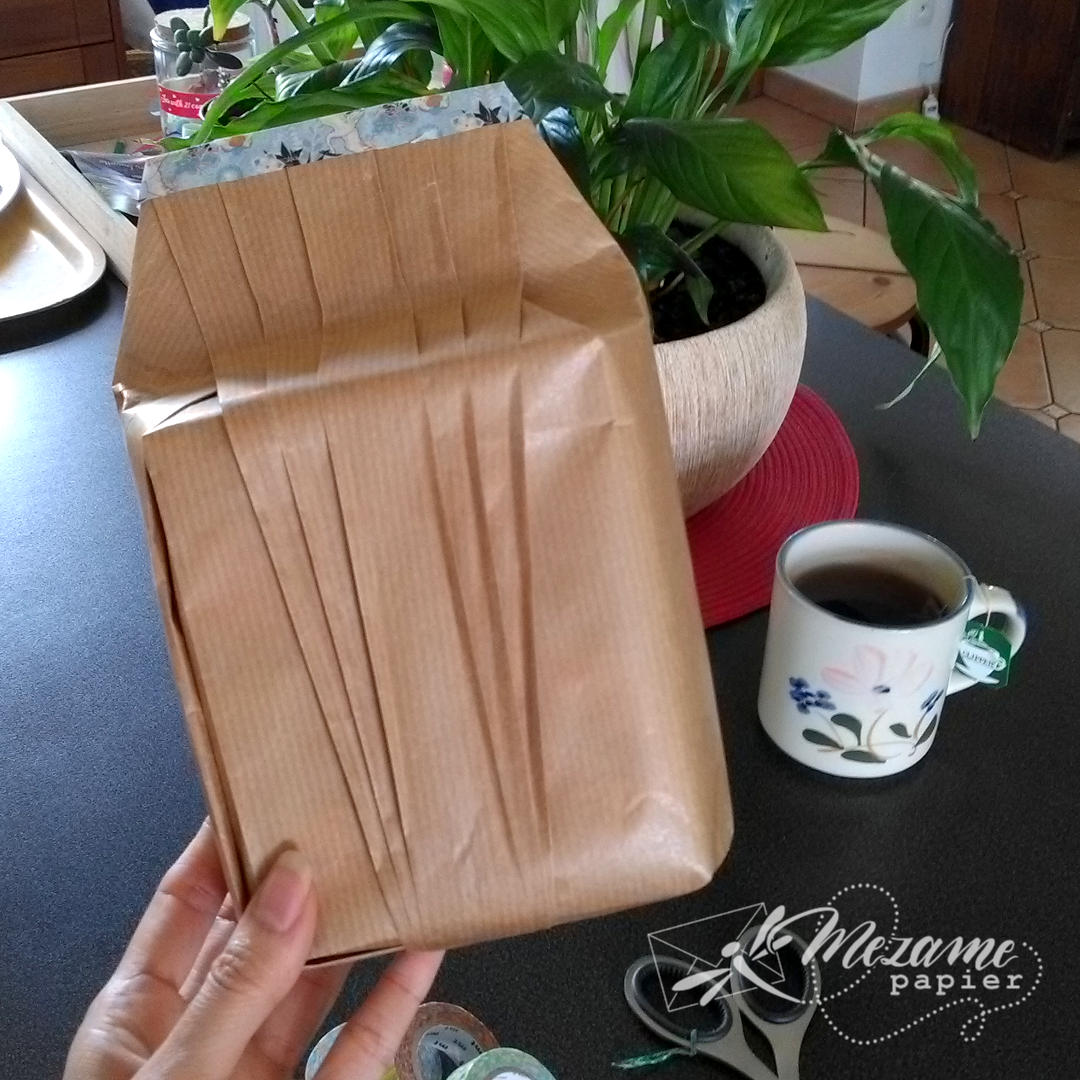Cadeau de forme difficile emballé dans du papier kraft brun uni avec plis décoratifs en forme d'éventail de l'école Shiho Masuda